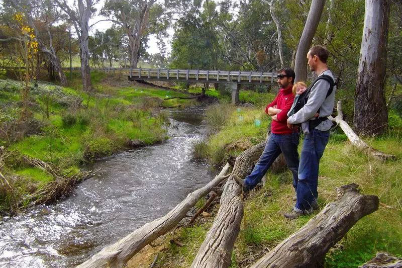 Two people with baby standing at McManus Rd Reserve